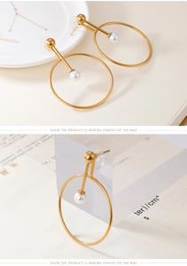 Detail of elegant gold hoop earrings with white faux pearl and minimalist bar design
