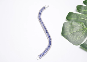 Detail of silver wavy bracelet with blue and white faceted stones and folding clasp