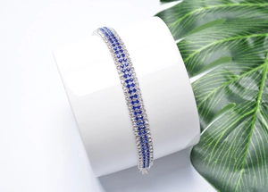 Close-up of sparkling silver and blue rhinestone double-row bracelet on display stand