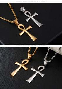 Detailed macro view of gold and silver Ankh cross pendants on a black leather background