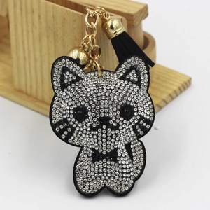 Macro detail of silver rhinestone cat keychain with black tassel and golden hardware