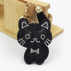 Detail of a black rhinestone cat keychain with golden metal chain and a black tassel charm