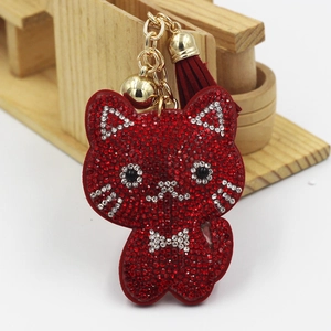 Macro shot of red rhinestone kitten keychain with gold bell and tassel details