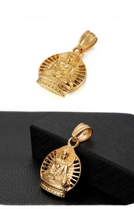 Détail macro d'un pendentif Bouddha doré avec rayons de lumière ajourés et ciselés