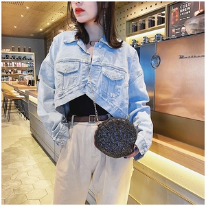 Detail of a chic black glitter shell bag with metal chain strap in a cafe setting