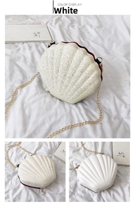 Close-up of white glitter shell bag with gold chain strap and pearl charm detail
