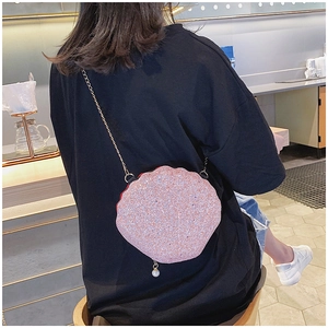 Pink glitter shell bag with gold chain and white pearl pendant shown on model