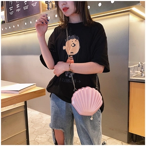 Pink shell-shaped crossbody bag with gold chain strap and pearl pendant on a model