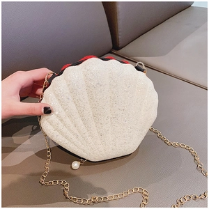 Detail of white sequin shell crossbody bag with gold chain and pearl ornament