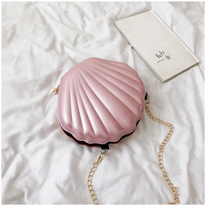 Detail shot of pink shell crossbody bag with pearl zipper and gold chain strap