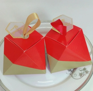 Close-up of pyramid candy boxes with gold foil Thank You tags and ribbon ties