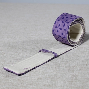 Close-up of purple clover pattern bake even strip on beige linen background fabric
