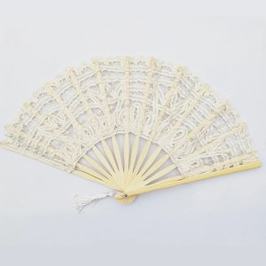 Close-up of beige lace folding fan with floral patterns and a small white tassel