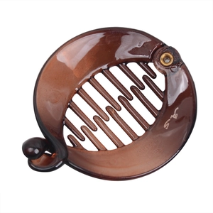 Detail of dark brown translucent banana hair clip with internal comb teeth and ball lock