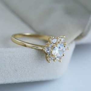 Vue détaillée de la bague fleur dorée avec zircon central et sertissage pavé brillant