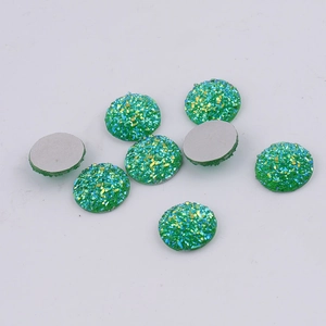 Close-up of green 14mm round resin flatback rhinestones with sparkling texture