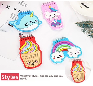 Close-up of four mini cartoon spiral notebooks with colorful unicorn and cupcake PVC covers