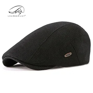 Classic black knitted flat cap for men featuring a gold metal brand plate on the side