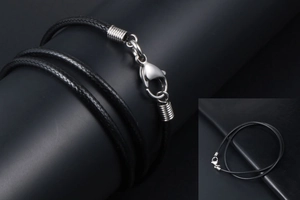Close-up of black braided necklace cord with silver spring ring and lobster clasp detail