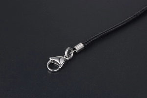 Detailed close-up of a black braided linen wax cord necklace with a silver lobster clasp