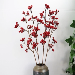 Rami di bacche rosse artificiali in un vaso di ceramica per decorazione domestica