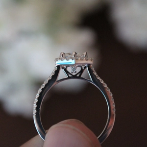 Classic white gold plated engagement ring with halo setting and zircon stones shown on hand