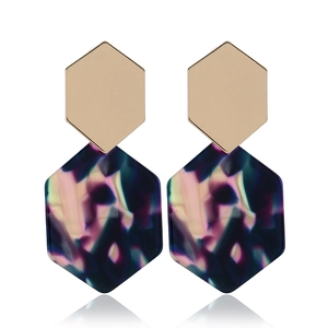 Detail view of hexagonal earrings featuring gold metal and iridescent dark blue resin
