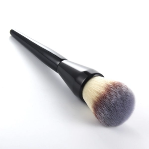 Macro detail of large powder brush with fluffy tri-color gradient bristles and black handle
