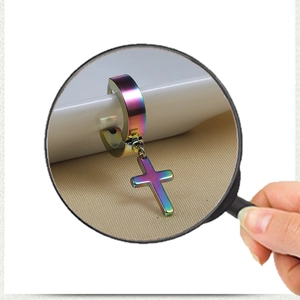 Macro view through magnifying glass showing rainbow cross pendant stainless steel hoop earring