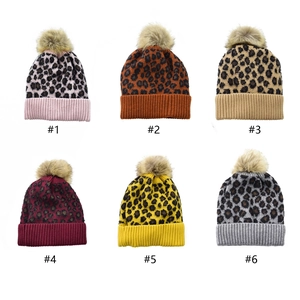 Detailed grid of leopard print knit hats with faux fur pom poms in six various colors