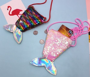 Close-up of rainbow and white sequin mermaid tail coin purses with lanyards and cards