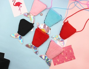 Flat lay of colorful mermaid tail coin purses in pink, blue, black, and red plush fabric