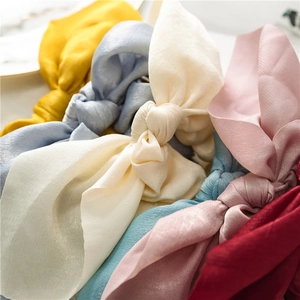 Close-up of assorted silky satin scrunchies with streamers in vibrant colors