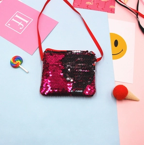 Detail shot of shimmering red and black sequin kids crossbody bag with red strap.