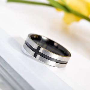 Macro shot of silver brushed metal ring with black cross patterns and polished inner band