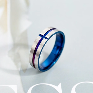 Detail of vintage silver ring with blue inner band and engraved cross on brushed surface