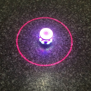 Colorful musical LED spinning top toy with vibrant red laser projection for children