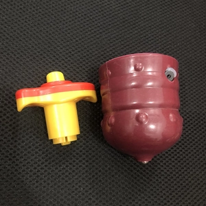 Detail of a dark red colorful spinning top toy with a red and yellow launcher handle