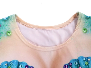 Detail view of crew neck and mermaid seashell print on light pink long sleeve shirt