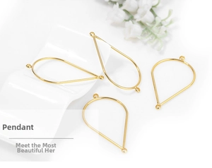 Detailed view of four golden teardrop-shaped metal pendant frames for DIY jewelry
