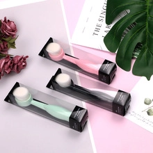 Three facial brushes in pink, black, and green packaging with soft white bristles