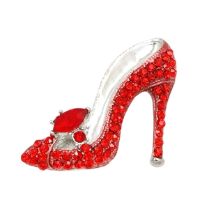 Elegant silver high heel brooch with sparkling red rhinestones on a clean white background
