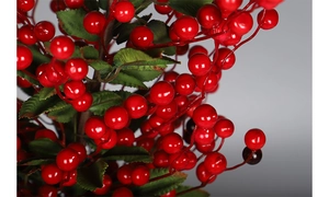 Detailed close-up of glossy red artificial berries and green leaves for Christmas DIY