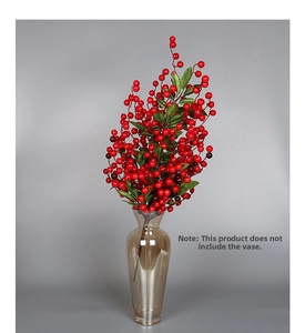Detail of red artificial berry stems with glossy berries and green leaves for decoration