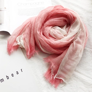 Detailed close-up of a pink and white gradient cotton linen scarf with fringe tassels