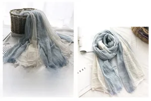 Detail of blue and white gradient linen scarf with pleated texture and frayed edges