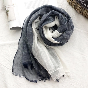 Detail of navy blue and white cotton linen scarf featuring soft fringe and textured fabric