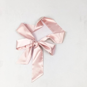 Ceinture en satin rose nouée en nœud pour robes, vue à plat sur fond blanc