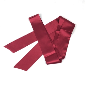 Vue détaillée de la ceinture en satin bordeaux avec texture soyeuse et fini brillant