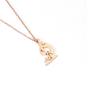 Macro detail of microscope pendant in 18K rose gold finish on minimalist white background